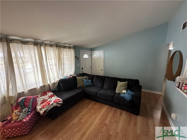 living room featuring vaulted ceiling and hardwood / wood-style flooring