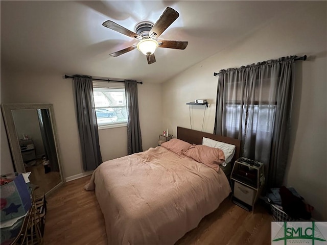 bedroom with ceiling fan, dark hardwood / wood-style flooring, and vaulted ceiling