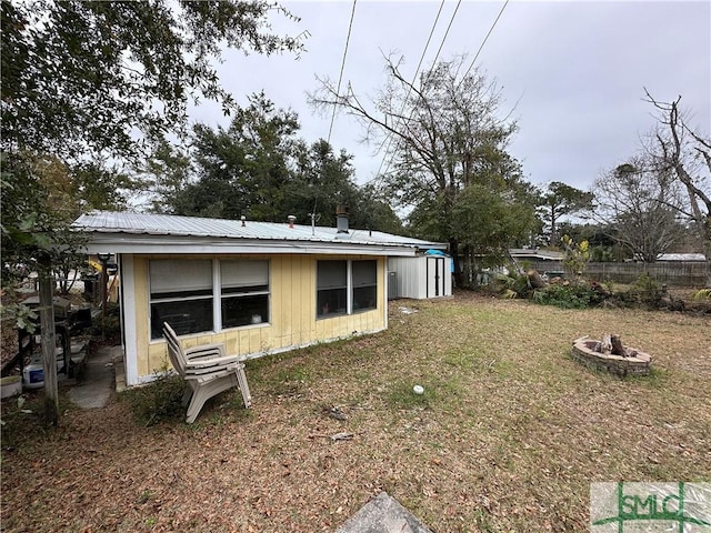 rear view of house featuring an outdoor fire pit