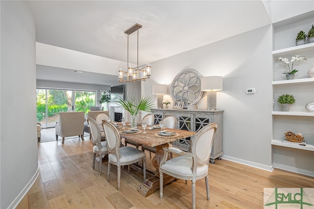 dining area featuring an inviting chandelier and light hardwood / wood-style flooring