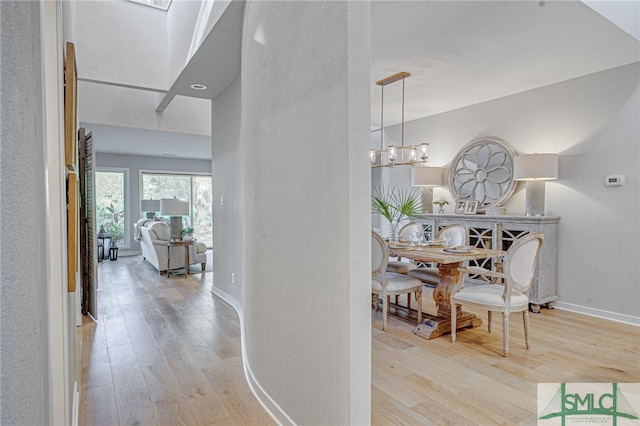 hallway featuring light hardwood / wood-style floors and a notable chandelier