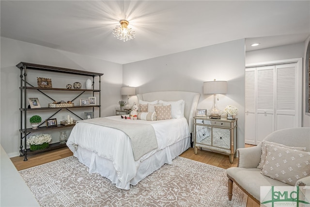 bedroom featuring light hardwood / wood-style flooring, a chandelier, and a closet