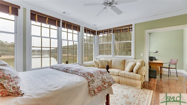 bedroom featuring access to outside, multiple windows, wood-type flooring, and ceiling fan