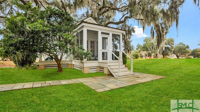 view of outbuilding with a sunroom and a lawn