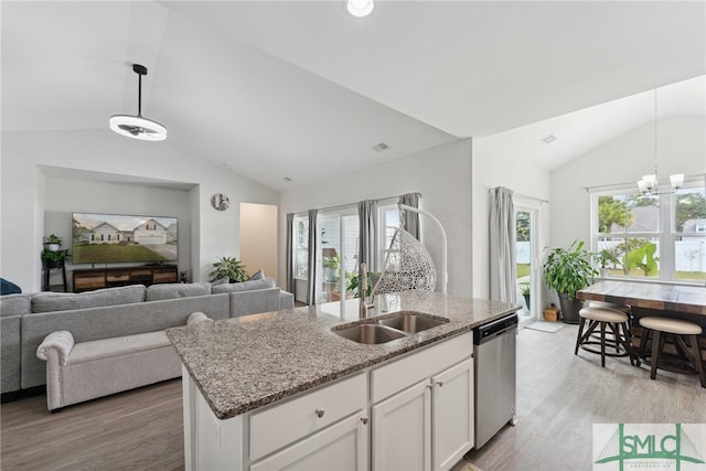 kitchen featuring hanging light fixtures, white cabinetry, a center island with sink, and dishwasher