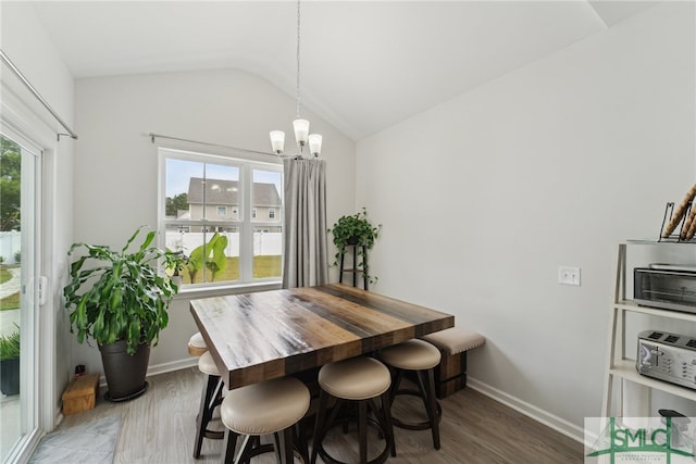 dining room featuring dark hardwood / wood-style floors, a chandelier, and lofted ceiling