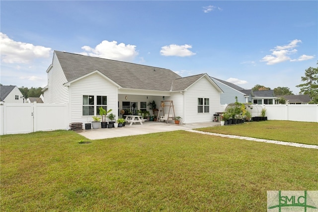 rear view of property with a patio and a yard