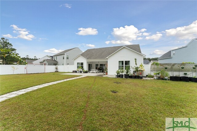 rear view of property featuring a patio and a lawn