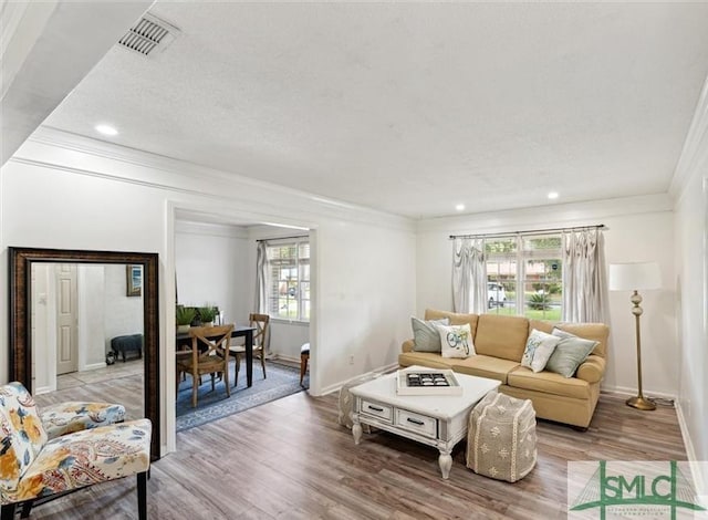 living room featuring hardwood / wood-style floors and crown molding