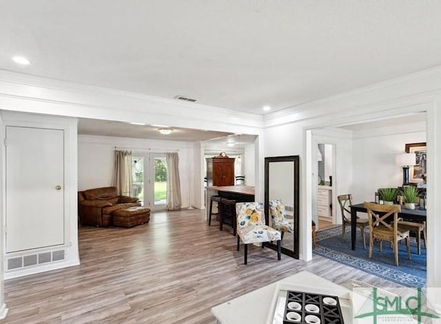 living room featuring crown molding, hardwood / wood-style floors, and french doors