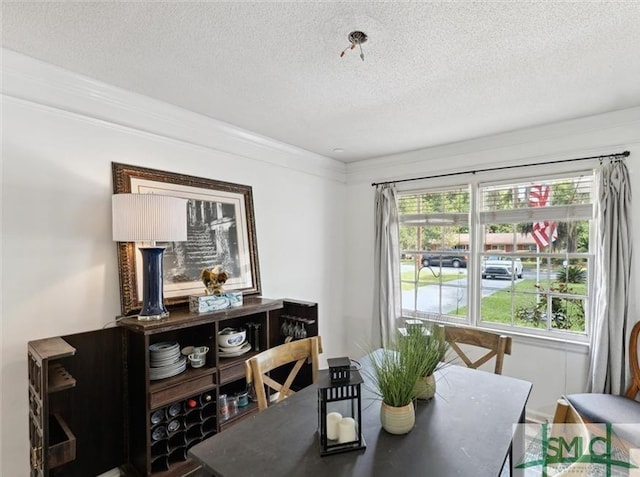 dining space with a textured ceiling and ornamental molding