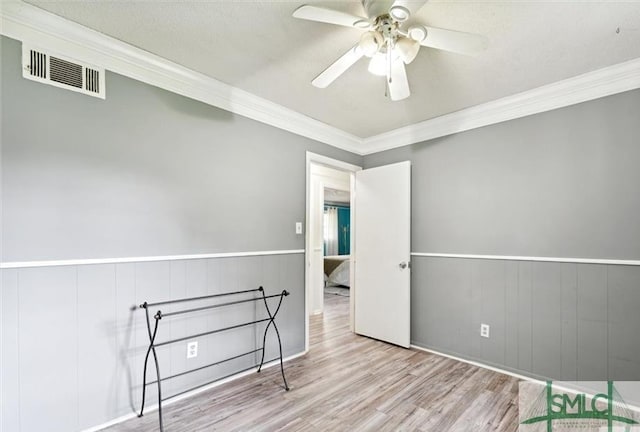 interior space with ceiling fan, ornamental molding, and light hardwood / wood-style flooring