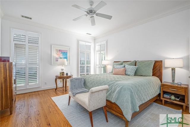 bedroom with visible vents, baseboards, a ceiling fan, ornamental molding, and light wood finished floors