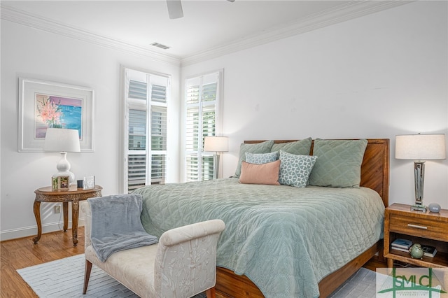 bedroom with ceiling fan, ornamental molding, and wood-type flooring