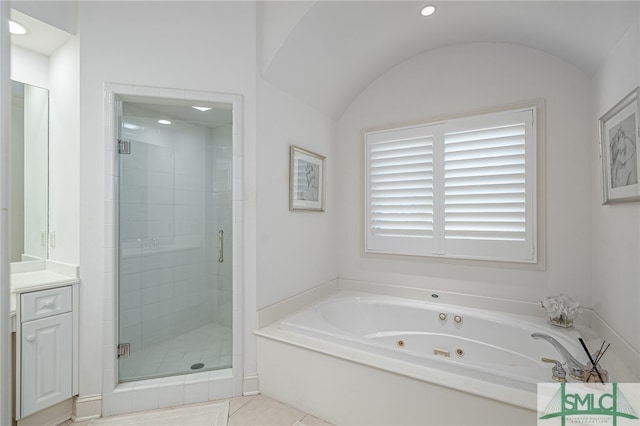 bathroom featuring lofted ceiling, tile patterned flooring, vanity, a jetted tub, and a shower stall