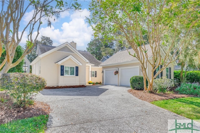 view of front of house featuring driveway, a shingled roof, a chimney, and stucco siding