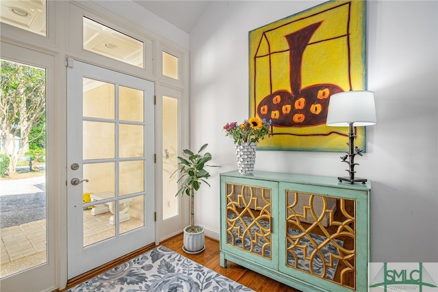 doorway with baseboards and wood finished floors