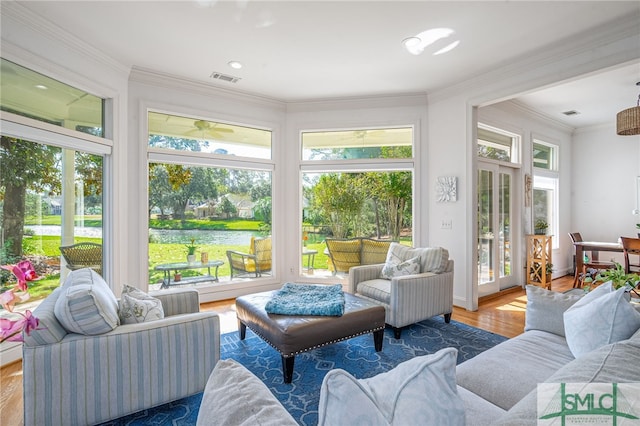 sunroom / solarium with a water view and visible vents