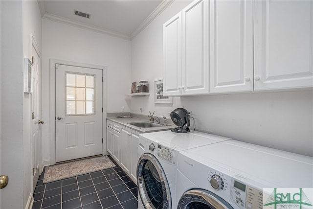 clothes washing area with dark tile patterned flooring, cabinets, sink, ornamental molding, and independent washer and dryer