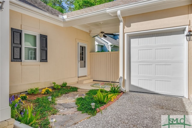 doorway to property with ceiling fan, roof with shingles, fence, a garage, and stucco siding