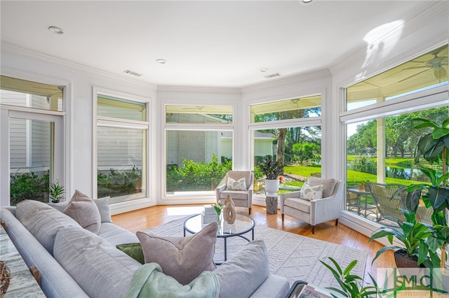 sunroom featuring wood finished floors and crown molding