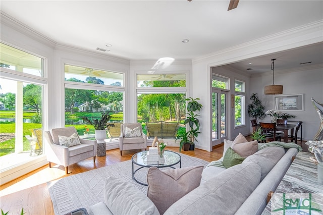 sunroom with wood finished floors and ornamental molding