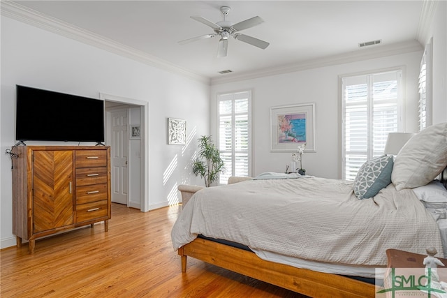 bedroom with light wood finished floors, ornamental molding, baseboards, and a ceiling fan