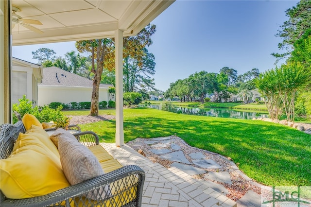 view of patio with a water view and ceiling fan