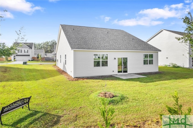 back of property with a lawn and a garage