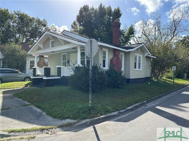 view of front of house featuring covered porch and a front lawn