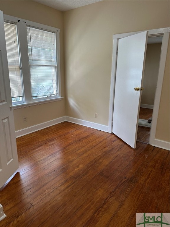 unfurnished room featuring dark hardwood / wood-style floors and a textured ceiling