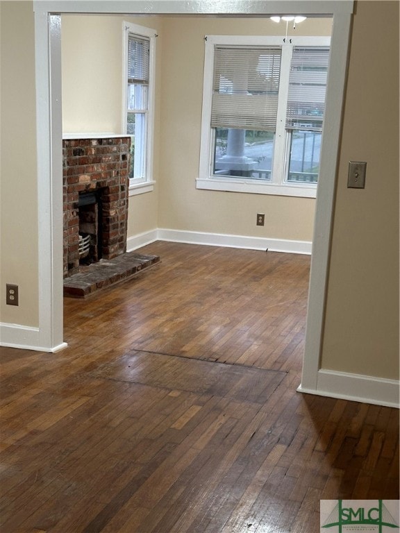 unfurnished living room with a fireplace and dark hardwood / wood-style floors