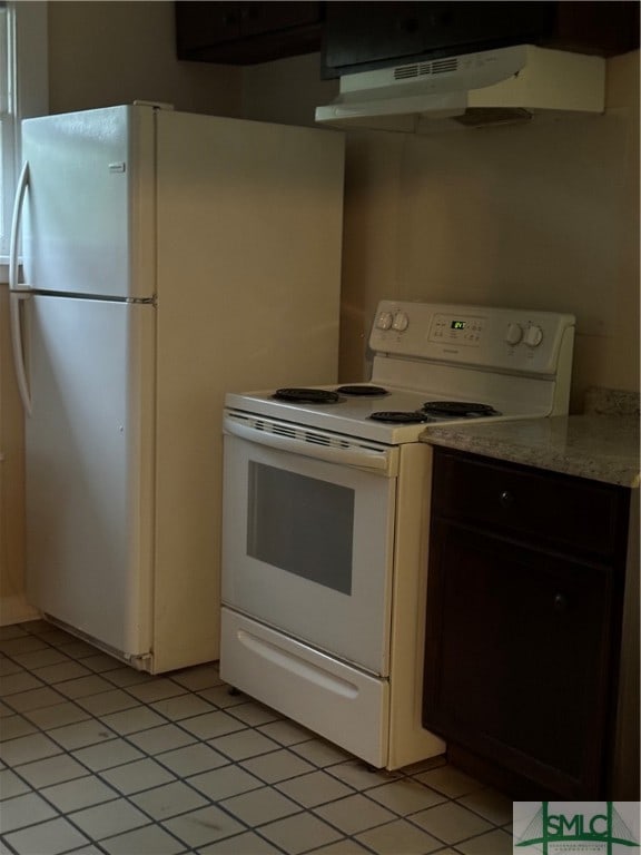 kitchen with white appliances, dark brown cabinets, light tile patterned flooring, and exhaust hood