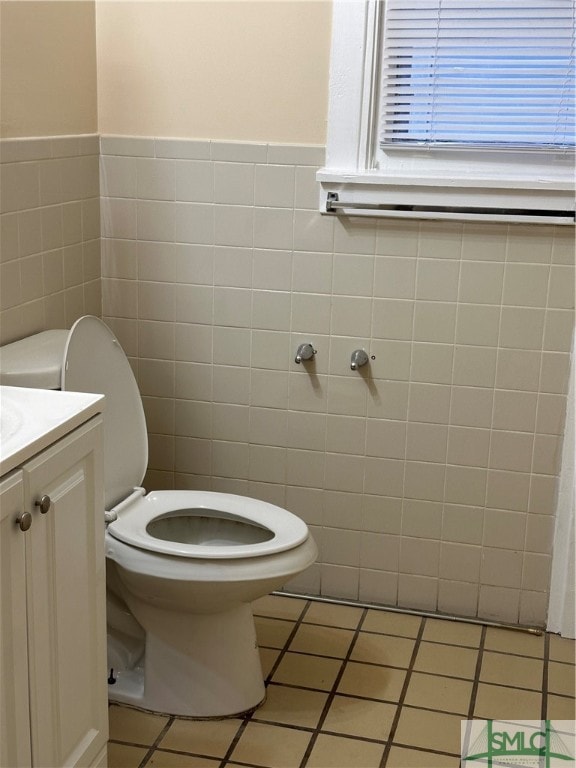 bathroom featuring vanity, tile patterned floors, toilet, and tile walls