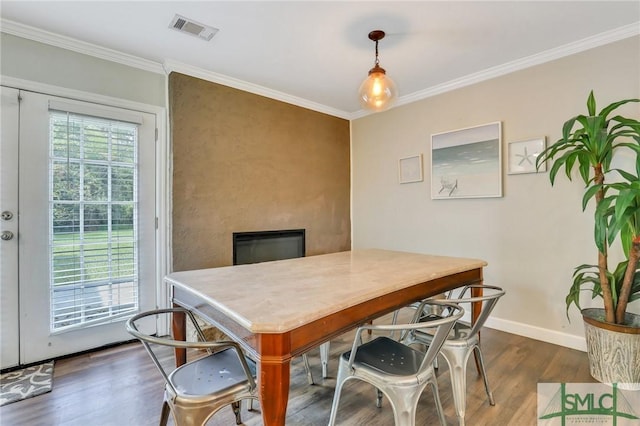 dining room with dark hardwood / wood-style floors, ornamental molding, and a fireplace