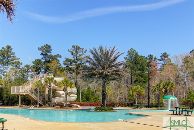 view of swimming pool featuring a patio area, pool water feature, and a water slide