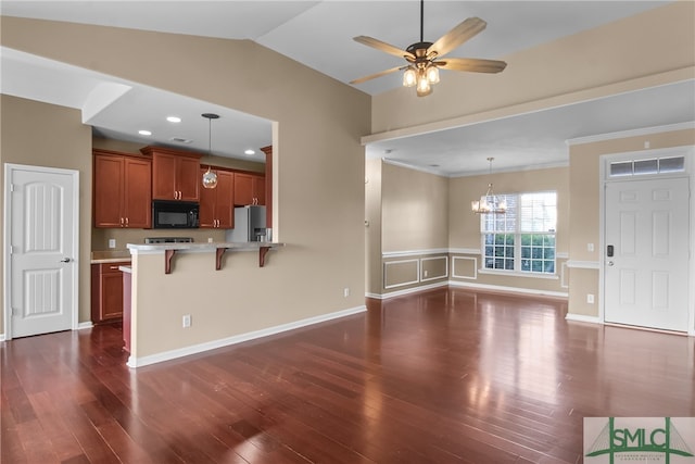 kitchen featuring a kitchen bar, dark hardwood / wood-style flooring, lofted ceiling, stainless steel refrigerator with ice dispenser, and decorative light fixtures