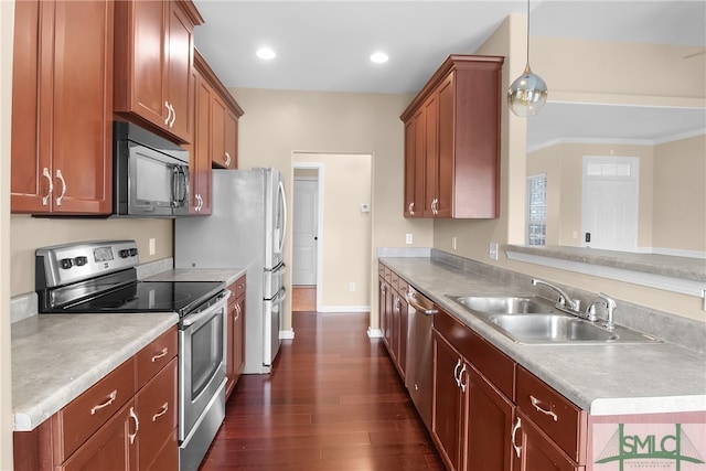 kitchen with crown molding, stainless steel appliances, hanging light fixtures, sink, and dark wood-type flooring