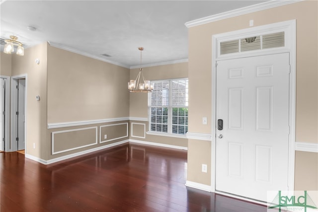 foyer entrance featuring a notable chandelier, dark hardwood / wood-style floors, and crown molding