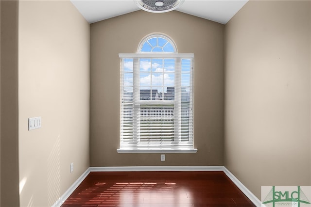 spare room with hardwood / wood-style flooring and vaulted ceiling