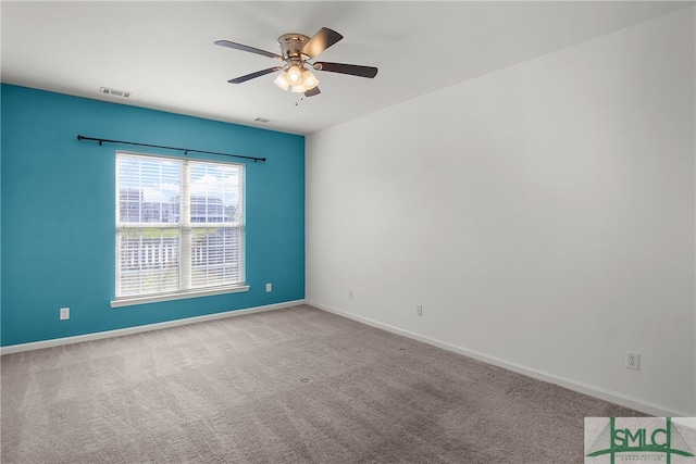 spare room featuring light carpet and ceiling fan