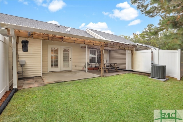 back of house with central AC, a patio area, and a lawn