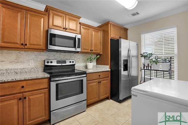 kitchen featuring stainless steel appliances, light tile patterned flooring, and ornamental molding