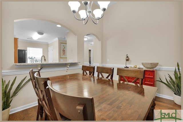 dining area featuring a notable chandelier, dark hardwood / wood-style floors, and crown molding