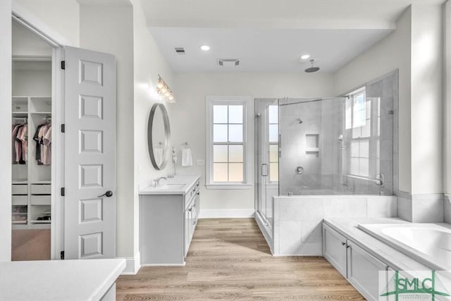 1495 Lillie Hagan Rd, Brooklet, GA 30415 - full bath with vanity, a shower stall, a bath, a walk in closet, and wood finished floors