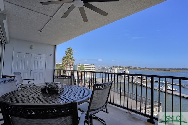 balcony with a water view and ceiling fan