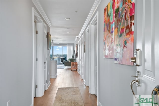 hall featuring light wood-type flooring and crown molding