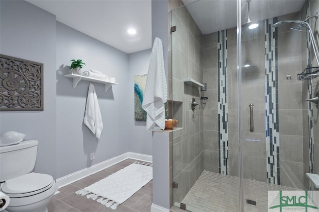 bathroom featuring a shower with shower door and toilet