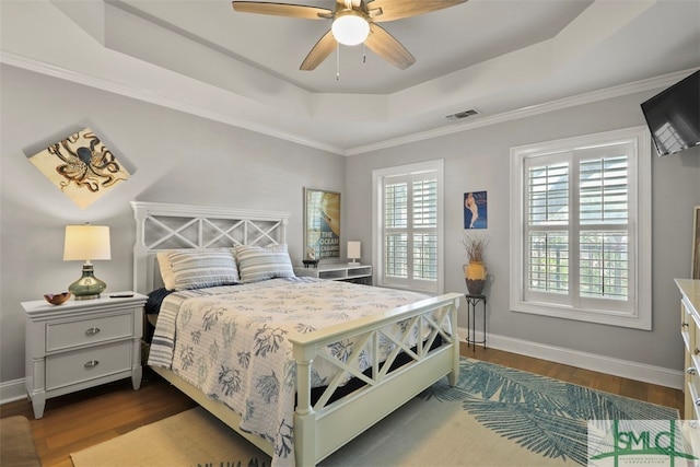 bedroom with a raised ceiling, ceiling fan, and dark hardwood / wood-style flooring