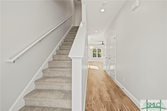 stairway with ceiling fan and hardwood / wood-style floors